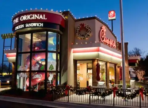 Restaurant decorated with roofline lights, garland and a wreath