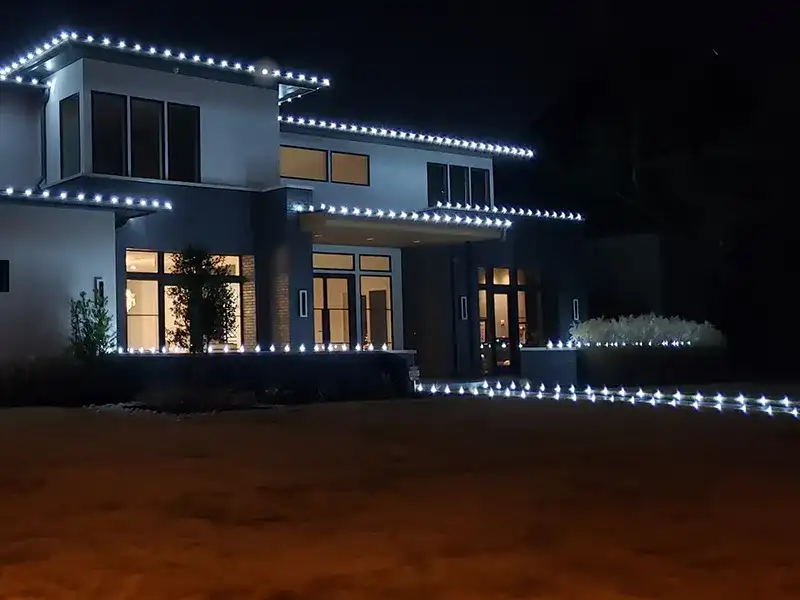 Modern home with white roofline lights and a lit front walkway