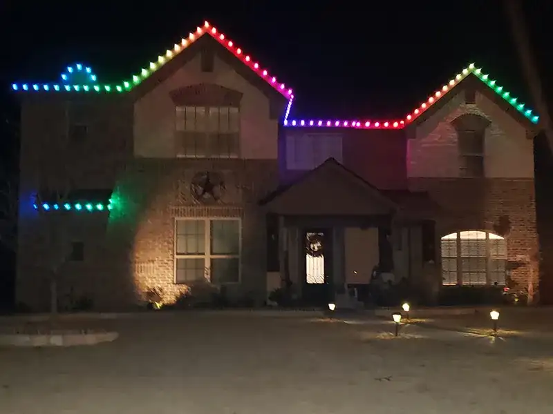 Brick home with multicolor RGB lights along the roofline